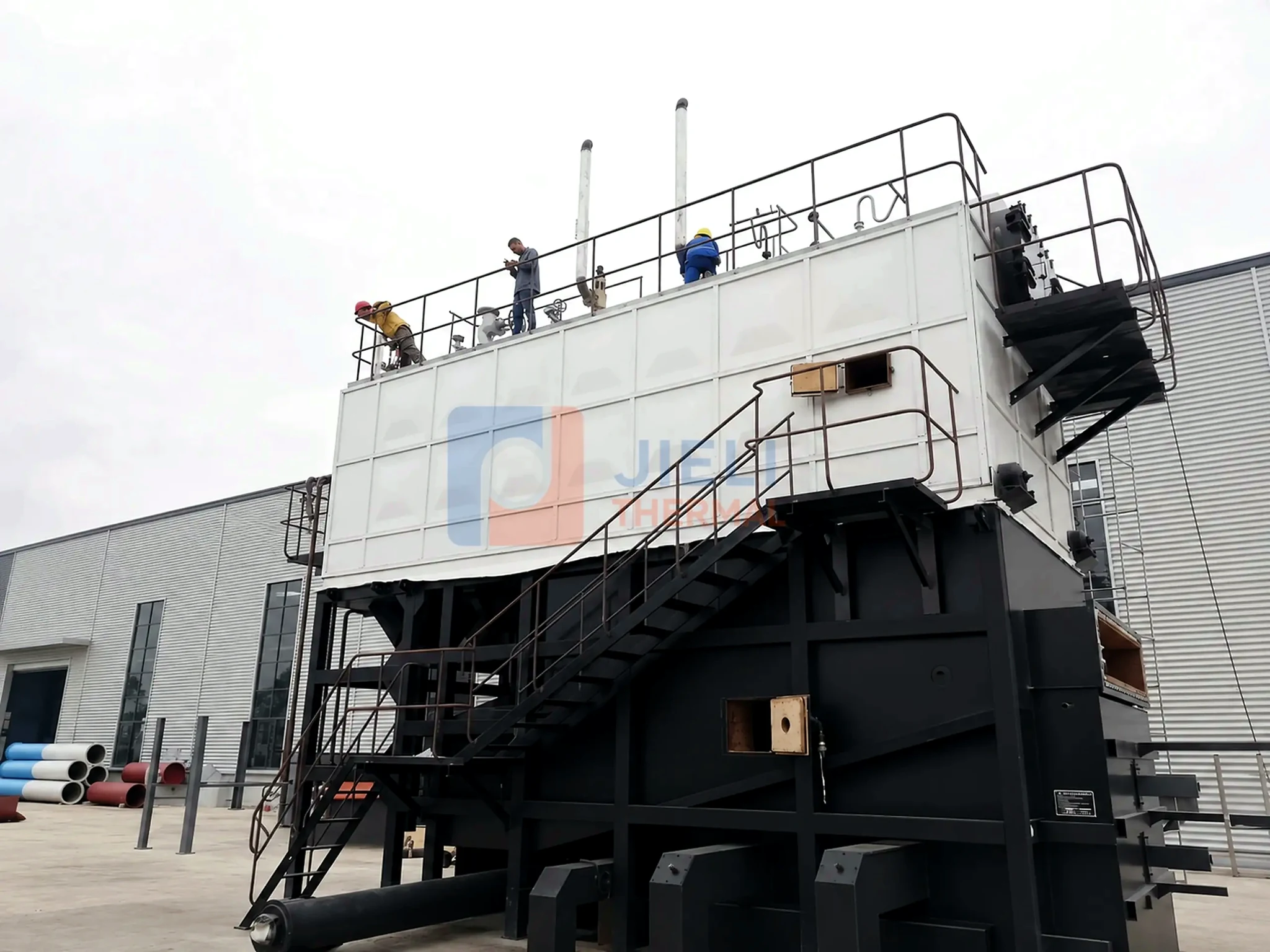 Biomass-fired steam boiler installation with service platforms and stairs