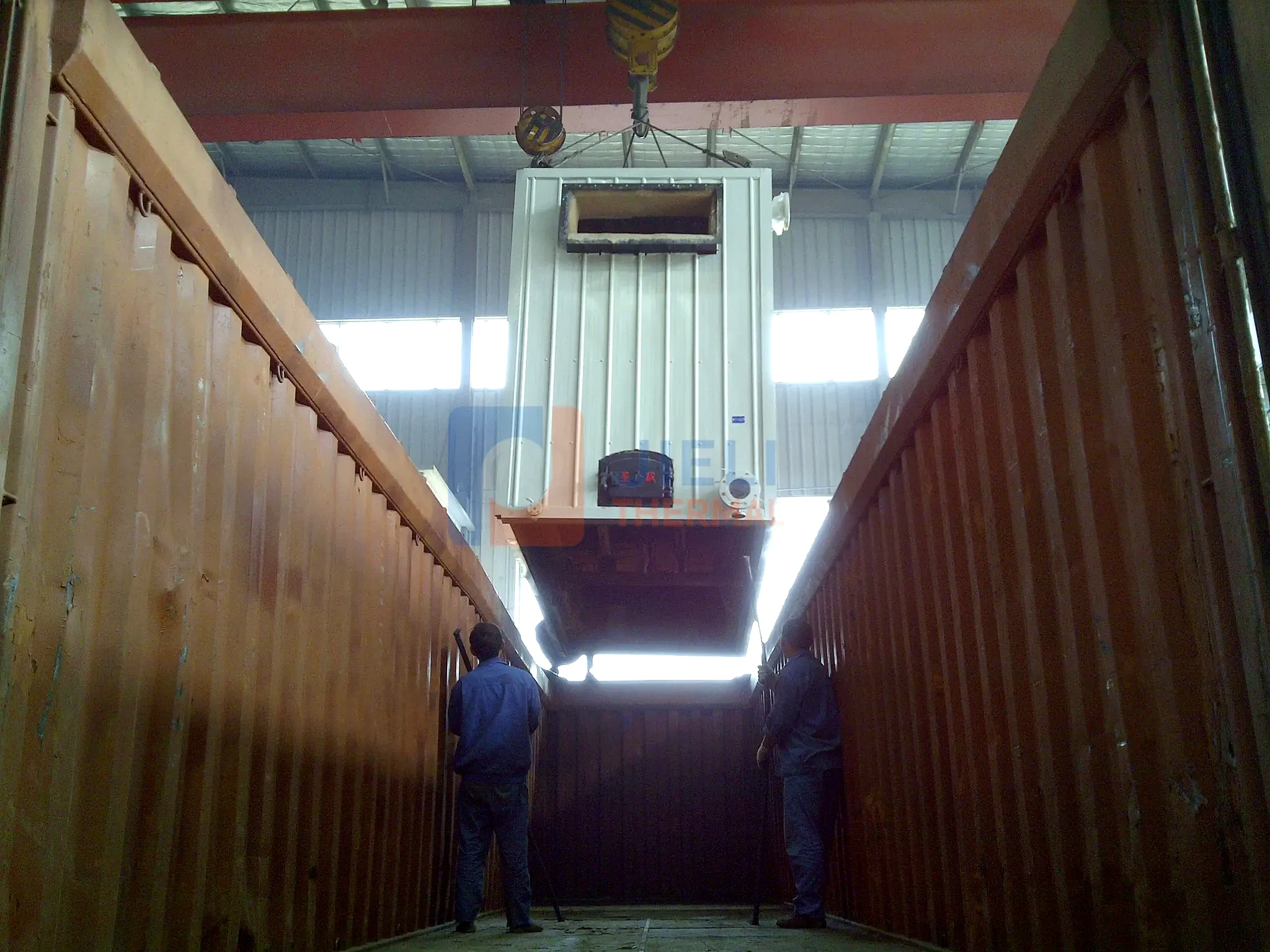 Industrial boiler export delivery — boiler module lowered into an open-top container