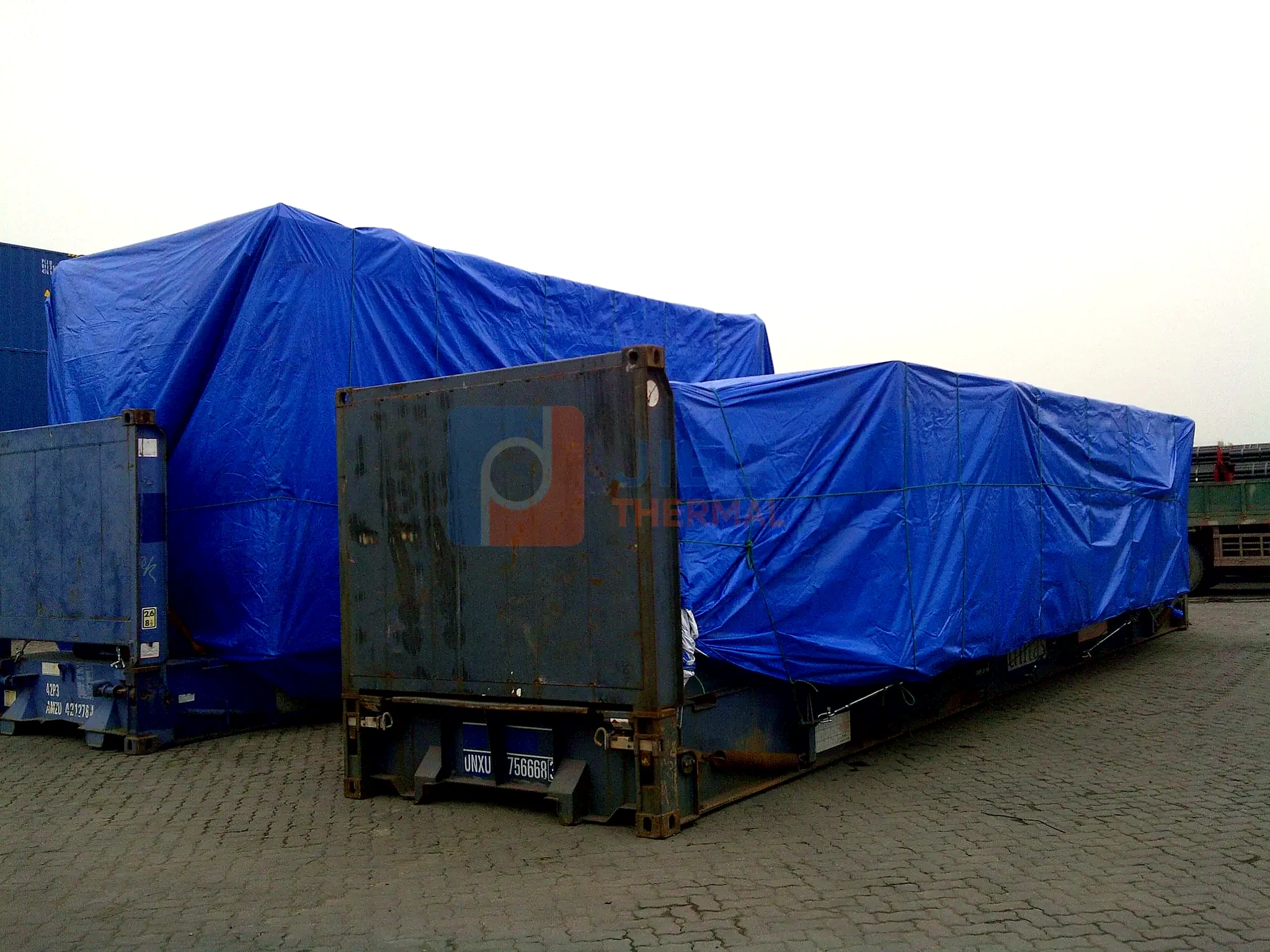 Industrial boiler export delivery — paired boiler packages protected on flat-rack containers
