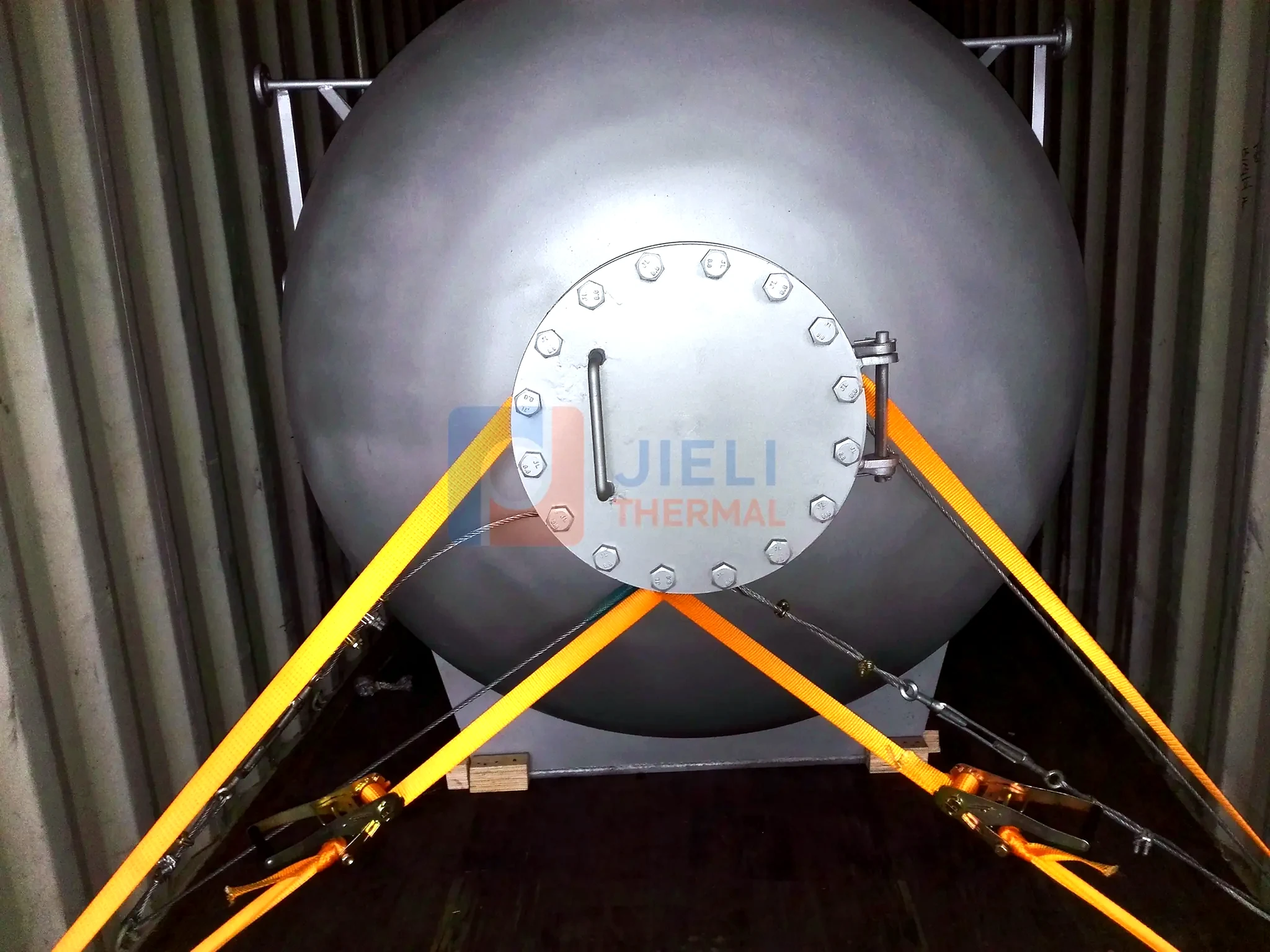 Industrial boiler export delivery — pressure vessel secured inside a shipping container