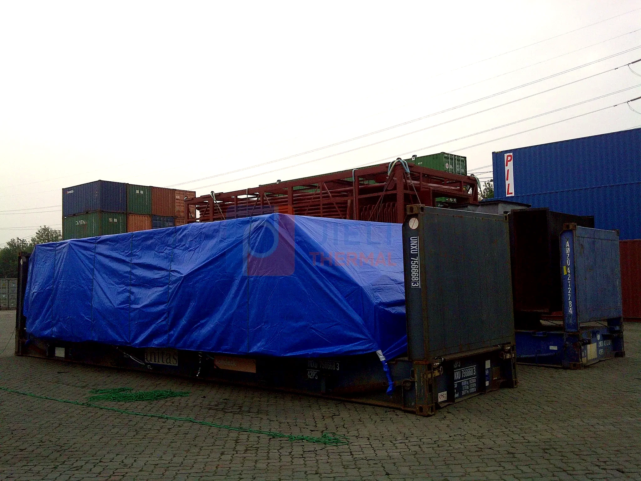 Industrial boiler export delivery — multiple tarped boiler modules in the export yard