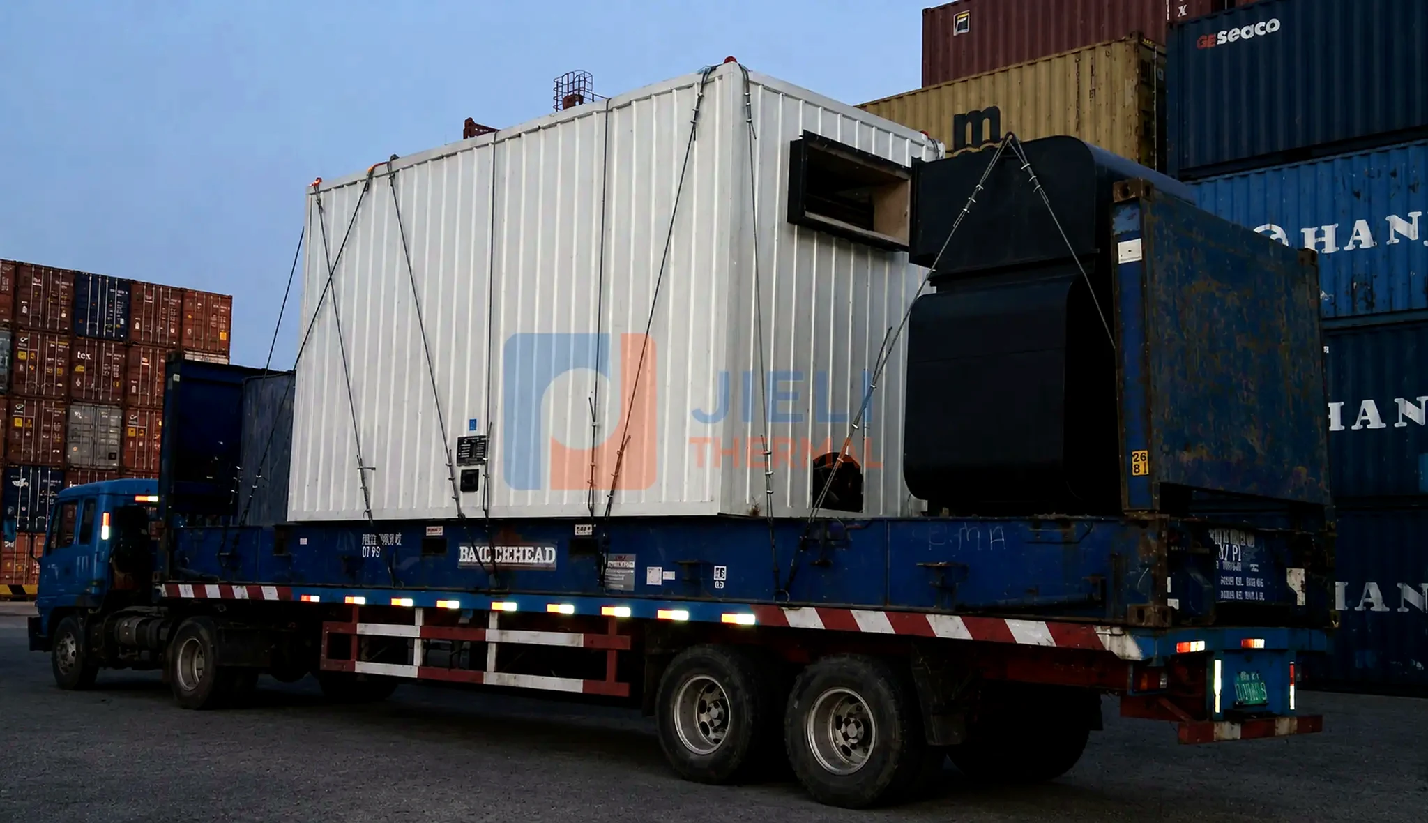 Industrial boiler export delivery — containerized thermal oil heater on a road truck