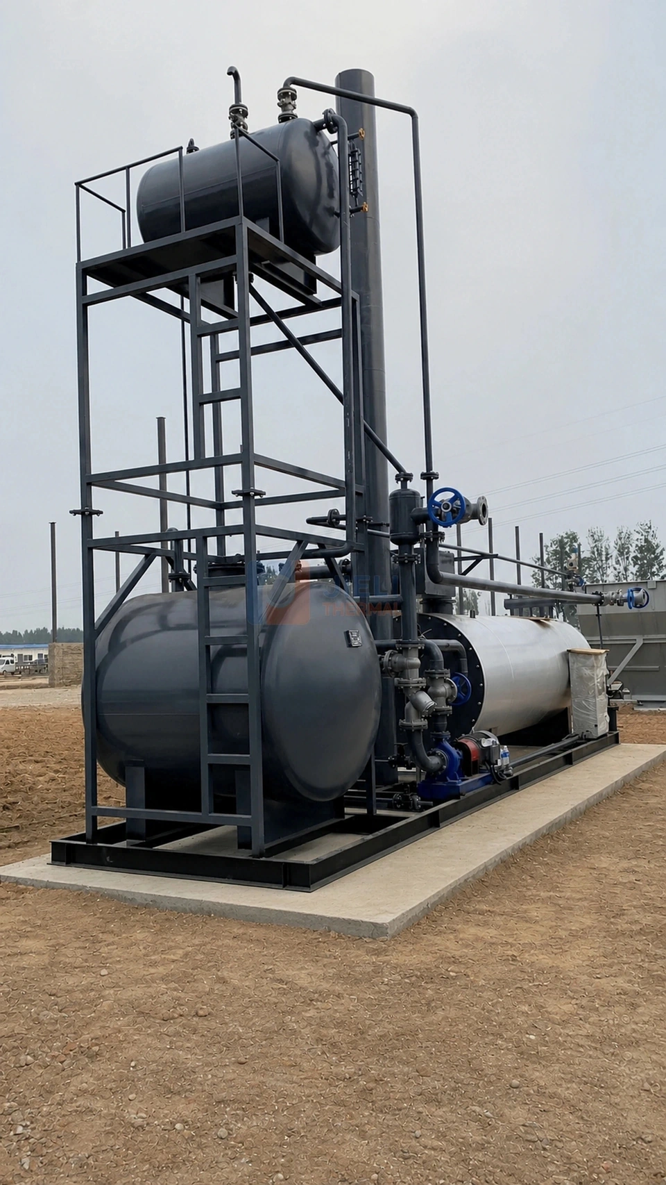 Site photograph of a skid-mounted fuel-fired thermal oil system with an elevated tank, access frame, circulation pipework and heater on a shared base